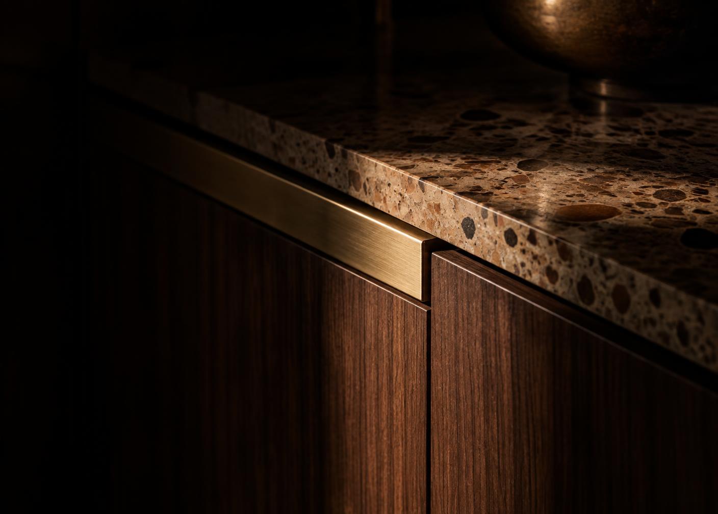 Material study of rift-sawn walnut cabinetry, brushed brass hardware and warm terrazzo